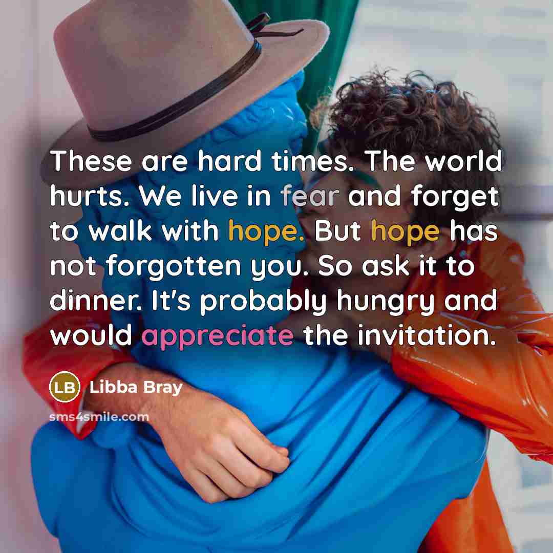 “These are hard times. The world hurts. We live in…” quote by Libba Bray
