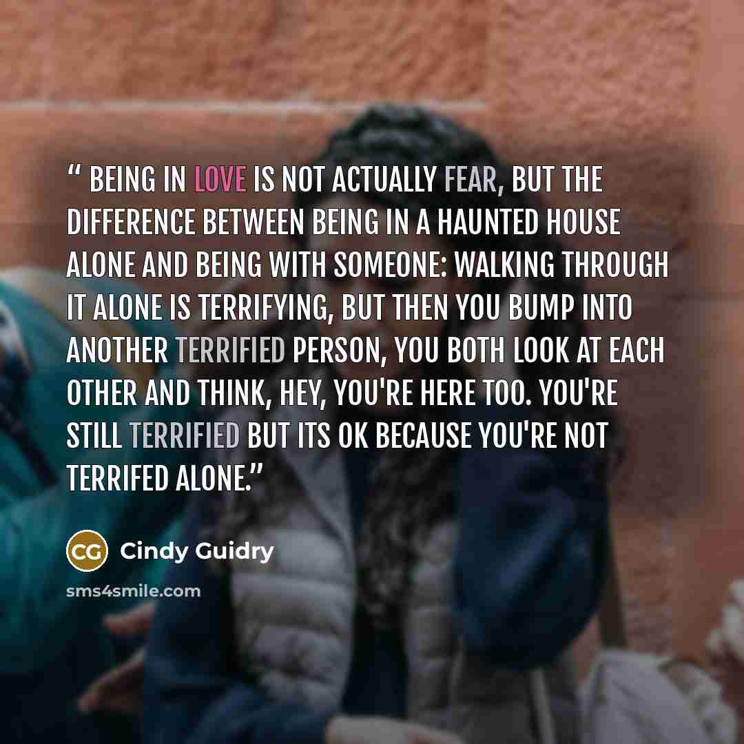“Being in love is not actually fear, but the difference between being in a haunted house alone and being with someone: walking through it alone is terrifying, but then you bump into another terrified person, you both look at each other and think, Hey, you're here too. You're still terrified but its…” quote by Cindy Guidry